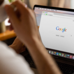 A person drinking coffee while browsing Google on a MacBook Pro, highlighting the risk when startups ignore digital marketing.