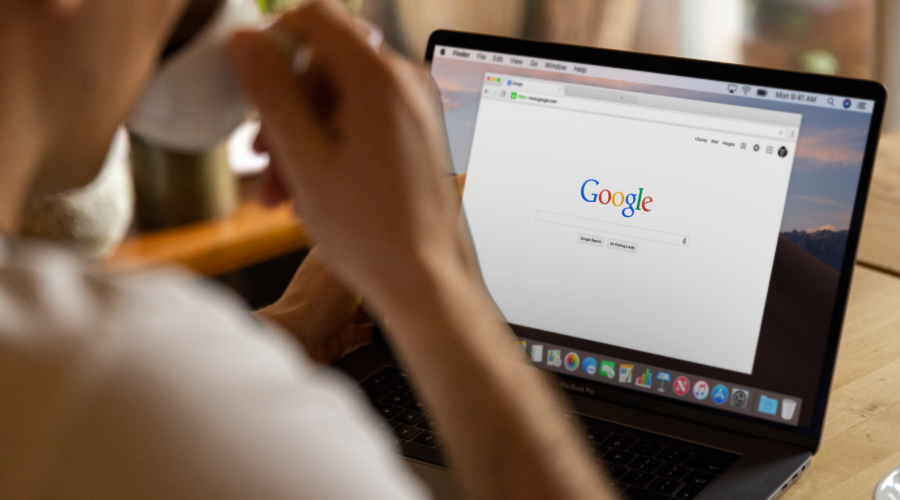 A person drinking coffee while browsing Google on a MacBook Pro, highlighting the risk when startups ignore digital marketing.